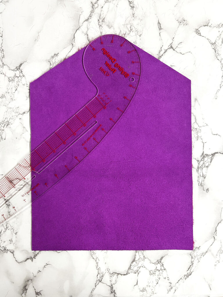 cutting fabric with a French curve ruler
